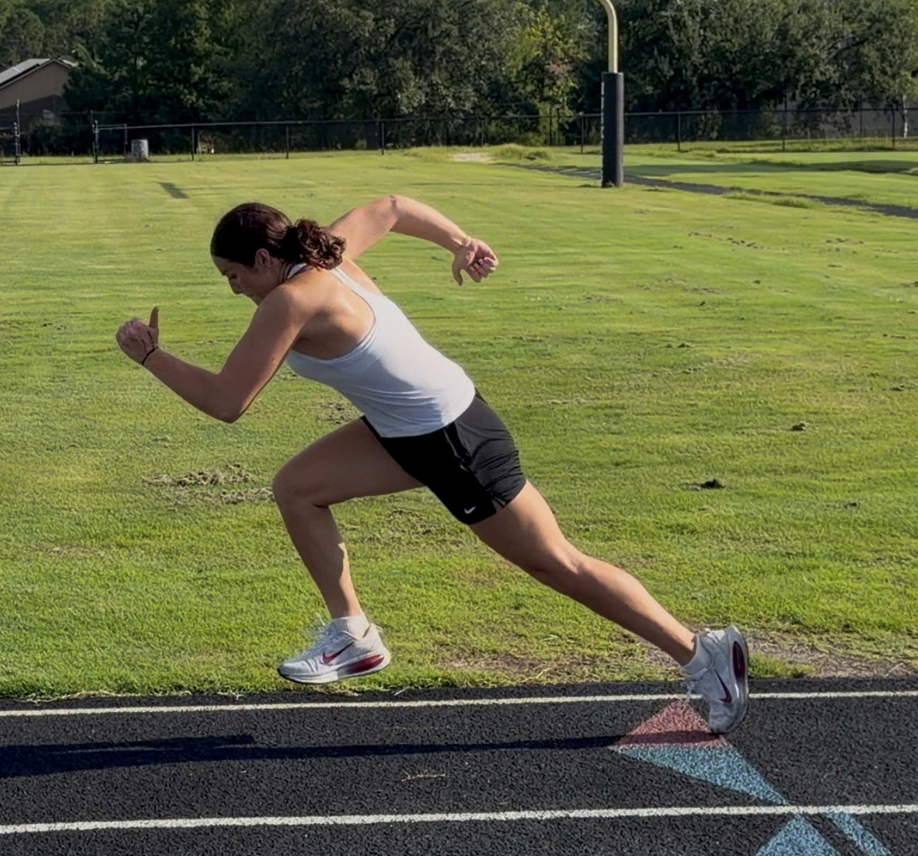 Same S3 athlete sprinting off the start after training, showing a stronger forward lean and more powerful leg drive